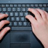 Zwei Hände tippen auf einer Tastatur.