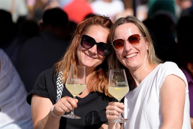 Zwei Frauen mit Weingläsern beim Feierabendmarkt in Dortmund
