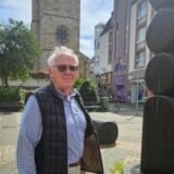 Kajo Krekeler steht auf dem Platz vor der Lambertus Kirche in Castrop-Rauxel neben einem Springbrunnen