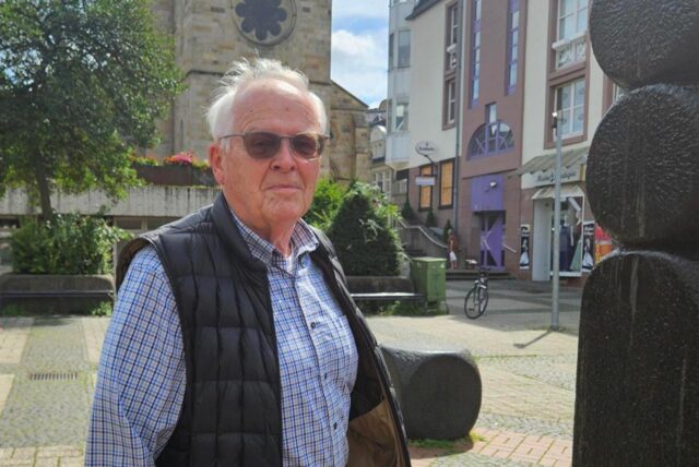 Kajo Krekeler steht auf dem Platz vor der Lambertus Kirche in Castrop-Rauxel neben einem Springbrunnen