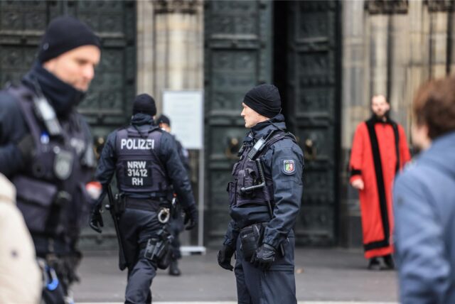 Polizisten stehen vor dem Kölner Dom.