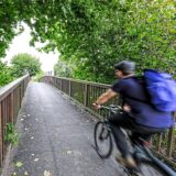 Ein Radfahrer fährt über eine Holzbrücke