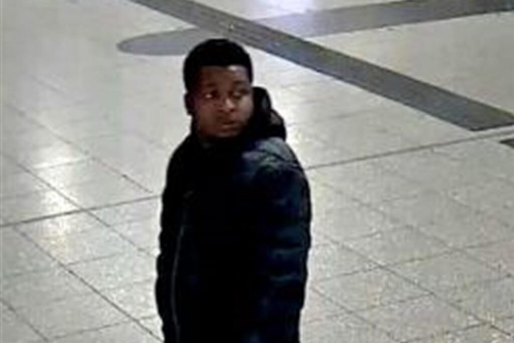 Das Foto zeigt eine Person: männlich, schlanke Statur, schwarze Haare, schwarze Jacke, blaue Jeans, schwarz-weiße Schuhe, schwarze Umhängetasche. Das Foto zeigt eine Person: männlich, schlanke Statur, schwarze Haare, schwarze Jacke, blaue Jeans, schwarz-weiße Schuhe, schwarze Umhängetasche.