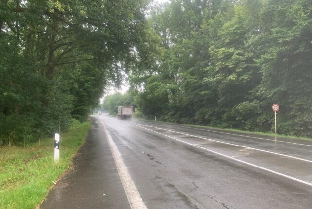 Ein Lkw fährt auf einer regennassen Landstraße.