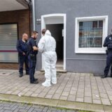 Gelsenkirchen: Mehrere Beamte stehen vor der Haustür des Mehrfamilienhauses, in dem die Frau tödlich verletzt worden ist.