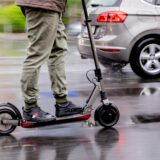Ein Mann fährt mit einem E-Scooter auf der Straße.