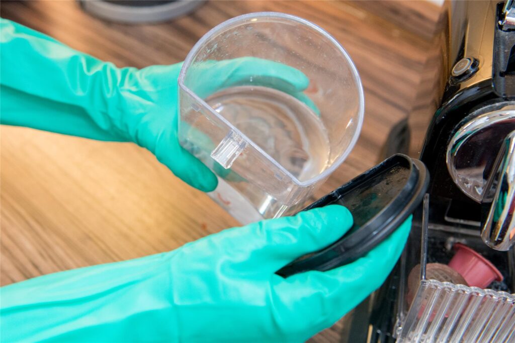 Wassertank einer Kaffeemaschine, der zum Reinigen und Entkalken der Kaffeemaschine entfernt wird. Wassertank einer Kaffeemaschine, der zum Reinigen und Entkalken der Kaffeemaschine entfernt wird.