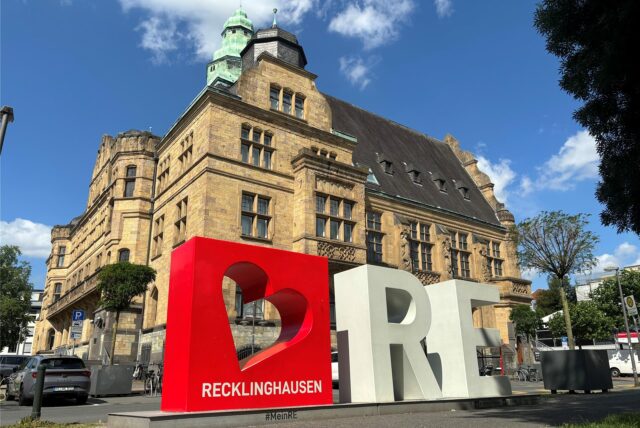 Das rot-weiße Love-RE-Logo steht auf der Ostseite des Recklinghäuser Rathauses. Die drei Elemente, ein in einem roten Quader ausgespartes Herz und die weißen Buchstaben R und E sind etwa zwei Meter hoch.