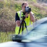 Ein Polizist schaut in ein Lasermessgerät