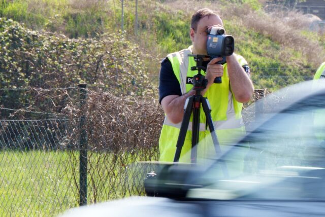 Ein Polizist schaut in ein Lasermessgerät