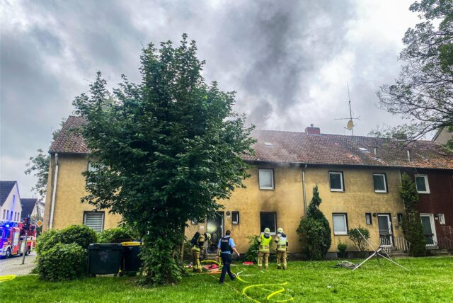 Aus einem Mehrfamilienhaus in Recklinghausen, in dem der Keller brennt, kommt Rauch.