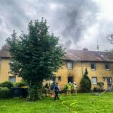 Aus einem Mehrfamilienhaus in Recklinghausen, in dem der Keller brennt, kommt Rauch.