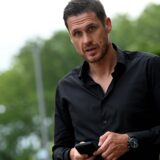 Sebastian kehl hält sein Handy in der Hand.