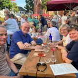 Männer und Frauen mit Weingläsern an einem Tisch