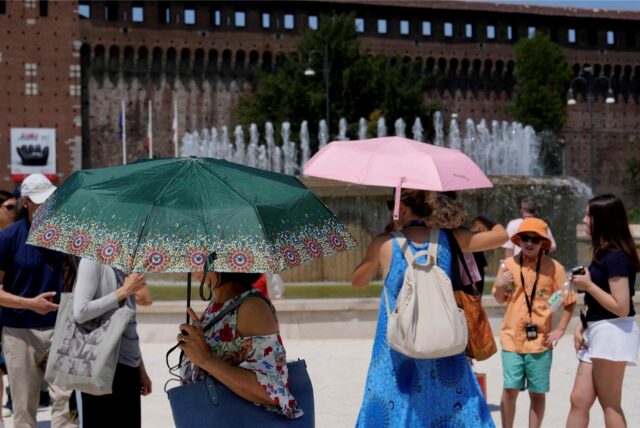 Menschen schützen sich mit Regenschirmen vor der Hitze in Mitteleuropa.