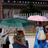 Menschen schützen sich mit Regenschirmen vor der Hitze in Mitteleuropa.