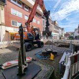 Ein Bagger steht in einer abgesperrten Baustelle.