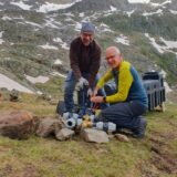 Zwei Männer mit Wasserleitungen in den Bergen