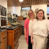 Andrea Coenen-Brinkert, Leiterin der Stadtbibliothek, und ihre Stellvertreterin Friederike Gernreich stehen in der alten Druckwerkstatt.