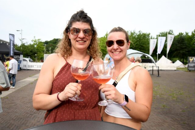 Zwei Frauen stoßen mit ihren Cocktails an.