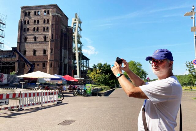 Martin Biehl steht auf dem Doncaster Platz und fotografiert die alten Gebäude der Zeche Ewald in Herten Süd.