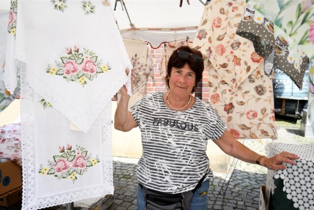 Die Hertenerin Ulla Vaerst steht am ihrem Marktstand inmitten von Tischdecken.