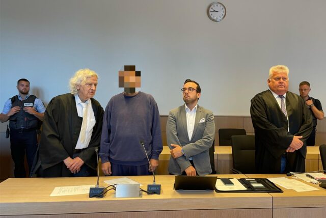 Der jetzt Freigesprochene (vorne 2.v.r.) neben seinem Verteidiger Siegmund Benecken (vorne links) und einem Dolmetscher beim Prozessauftakt am 22. Juli. Ganz rechts vorne: Verteidiger Michael Emde.