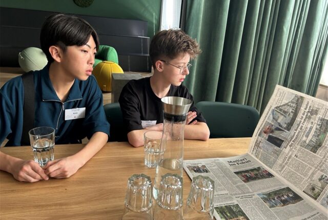 Zwei Jungs, die sich eine Zeitung anschauen.