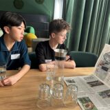 Zwei Jungs, die sich eine Zeitung anschauen.