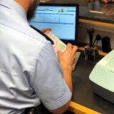 Ein Bundespolizist am Dortmunder Flughafen kontrolliert einen Reisepass.