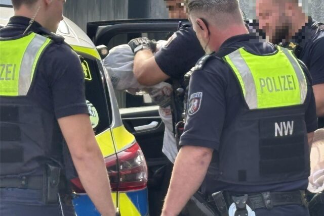 Polizisten nehmen den mutmaßlichen Täter fest, der am Dienstag einen Mann mit einem Messer bedroht haben soll.