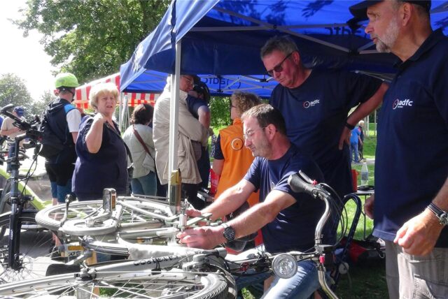 männer stehen an einem fahrrad