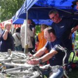 männer stehen an einem fahrrad