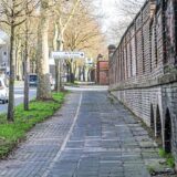 Gehweg neben einer alten Zechenmauer an der Suderwichstraße in Recklinghausen. Im Hintergrund ist ein Hinweisschild für die Zufahrt zum Gewerbegebiet RE-Ortloh König-Ludwig 4/5 Nord zu sehen. (Archivbild)