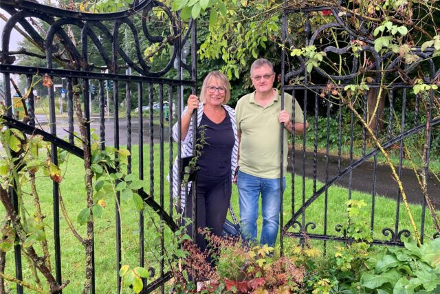 Jogi Lenort und Marianne Seidel stehen an dem Tor des ehemaligen Friedhofs an der Bergstraße, das derzeit am Rand des Resser Weges in Herten-Mitte steht.