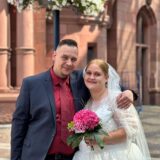 Mirko und Jenny stehen Arm in Arm vor dem Standesamt in Dortmund.