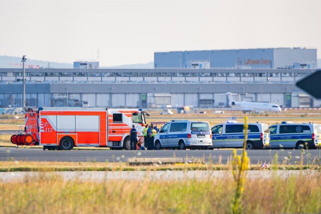 Einsatzfahrzeuge der Polizei stehen am Frankfurter Flughafen bei einer Aktion von Klimaaktivisten.
