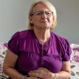 Frau mit Magenschmerzen und Edeka Tüte