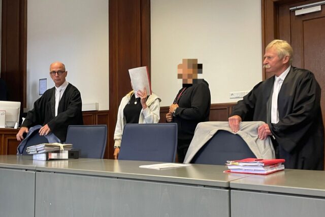 Die angeklagten Eltern (Mitte) an der Seite ihrer Verteidiger kurz vor Prozessbeginn am Landgericht Dortmund.