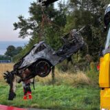 Zu sehen ist ein verbrannter Porsche, der von einme LKW angehoben wird.