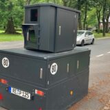 Eine semistationäre Geschwindigkeitsmessanlage steht auf der Hafenstraße in Datteln. Im Hintergrund fährt ein silberner Kleinwagen.