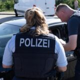 Zwei Polizisten kontrollieren einen Autofahrer (Symbolbild)