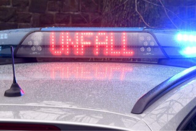 Das Wort Unfall in großen und roten Buchstaben auf einem Polizeiauto.