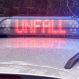 Das Wort Unfall in großen und roten Buchstaben auf einem Polizeiauto.