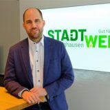 Stadtwerke-Geschäftsführer Dirk Wessling steht vor einem Werbelogo der Stadtwerke Recklinghausen.