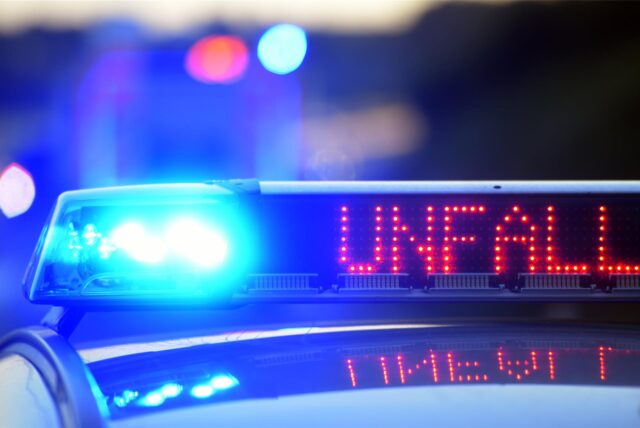 Auf einem Polizeifahrzeug warnt eine Leuchtschrift vor einer Unfallstelle.