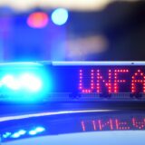 Auf einem Polizeifahrzeug warnt eine Leuchtschrift vor einer Unfallstelle.