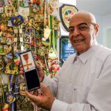 Mehdi Noheh-Khan aus Recklinghausen steht lächelnd mit weißem Hemd vor einer Wand voller Medaillen und Orden. In der Hand hält er eine Schatulle mit einem Bundesverdienstkreuz.