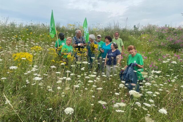 Mitglieder des BUND stehen auf einer Blumenwiese.
