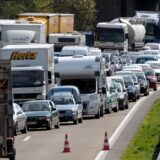 Ein Stau auf einer Autobahn: Hier wird von drei auf zwei Fahrspuren reduziert. Im Vordergrund ist die Absperrung der dritten Spur zu erkennen.